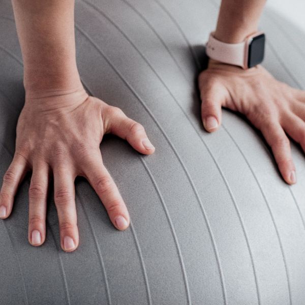 Hands resting on an exercise ball