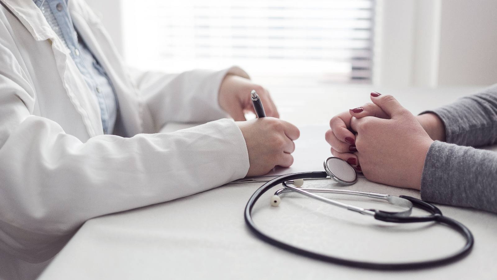 Doctor taking notes during a consultation